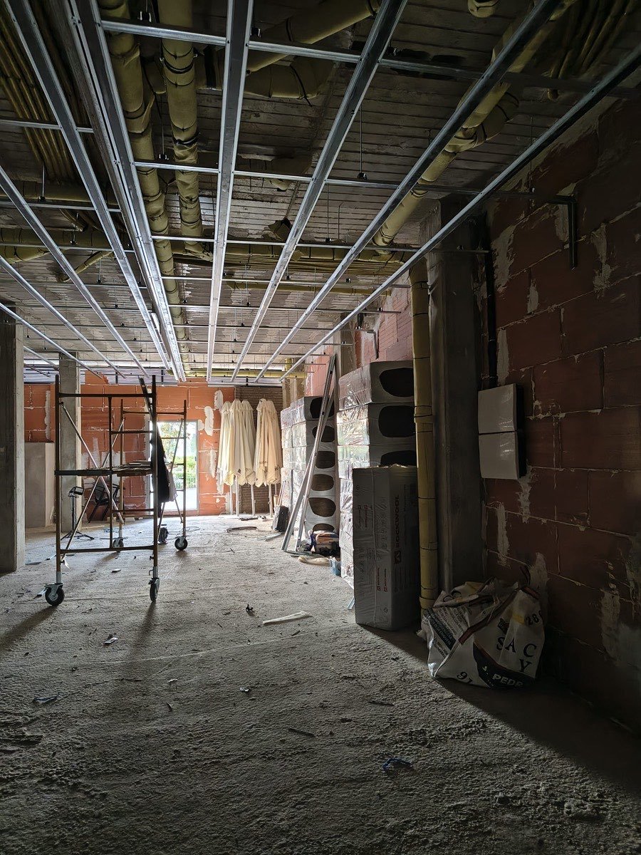 Obra del gimnasio boutique Hybrid Strength Method en Fuenlabrada: sala principal con la estructura del techo y los conductos instalados